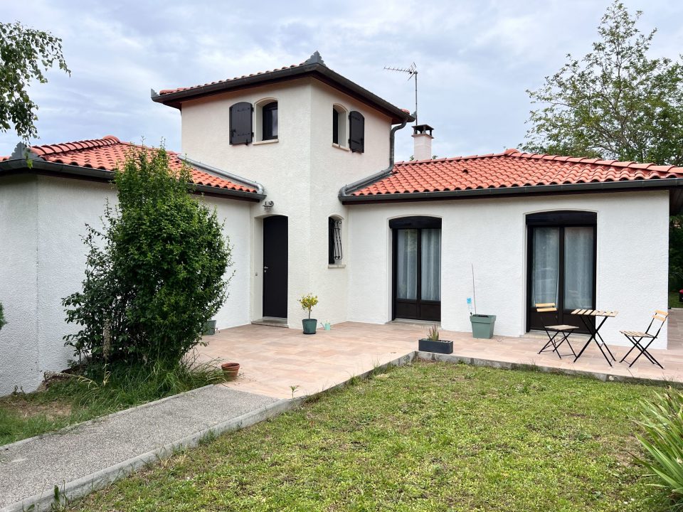 Maison blanche avec toits rouges, portes et fenêtres noires, Espace Façades.