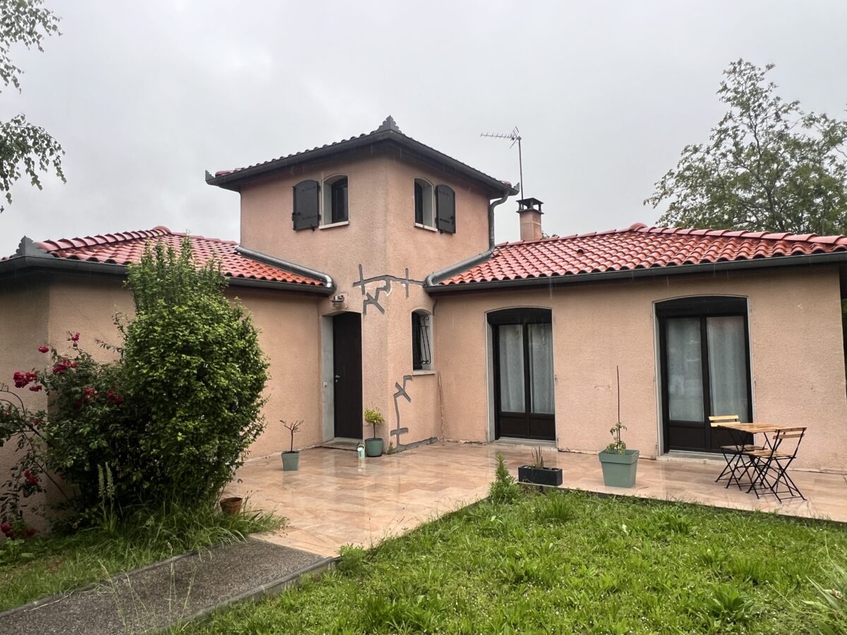 Maison avec façades beiges et espaces extérieurs aménagés