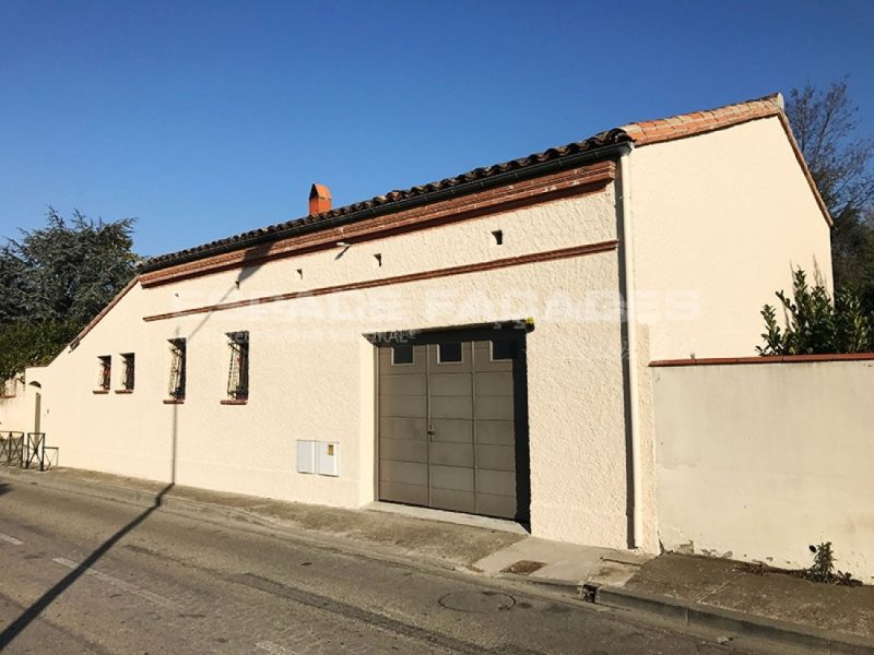 Façade de maison rénovée avec crépi clair et porte de garage Espace Façades
