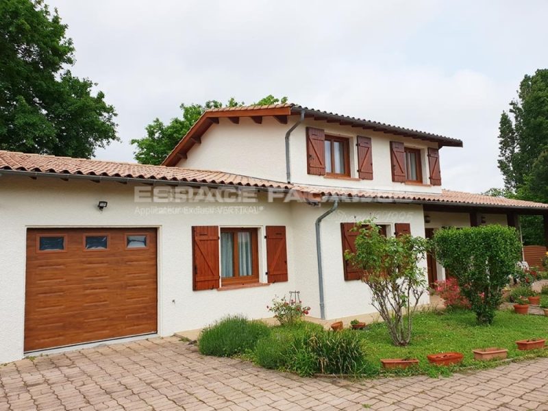 Façade de maison rénovée par Espace Façades avec volets et garage bois