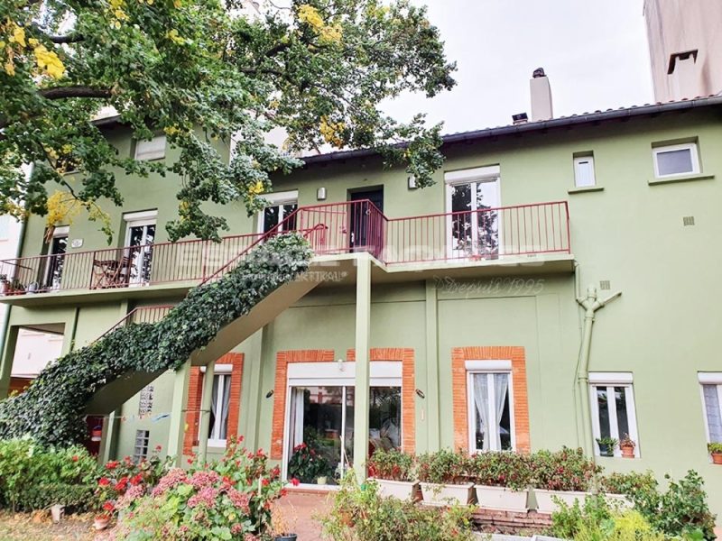 Façade de maison verte avec escalier extérieur et balcon, Espace Façades