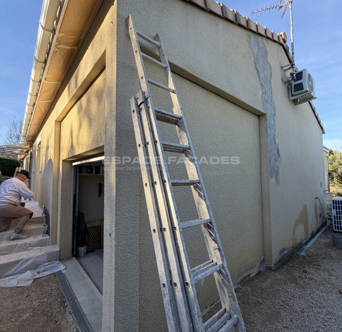 Ravalement de façade en cours par Espace Façades avec échelle et enduit réparé