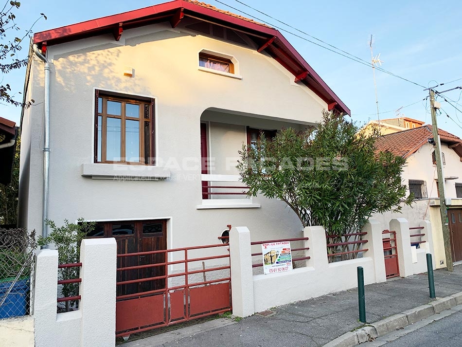 Maison jaune avec clôture rouge, fenêtres en bois, Espace Façades.