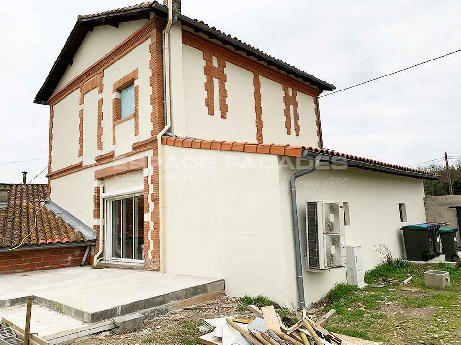 Maison en construction, façade partiellement terminée.