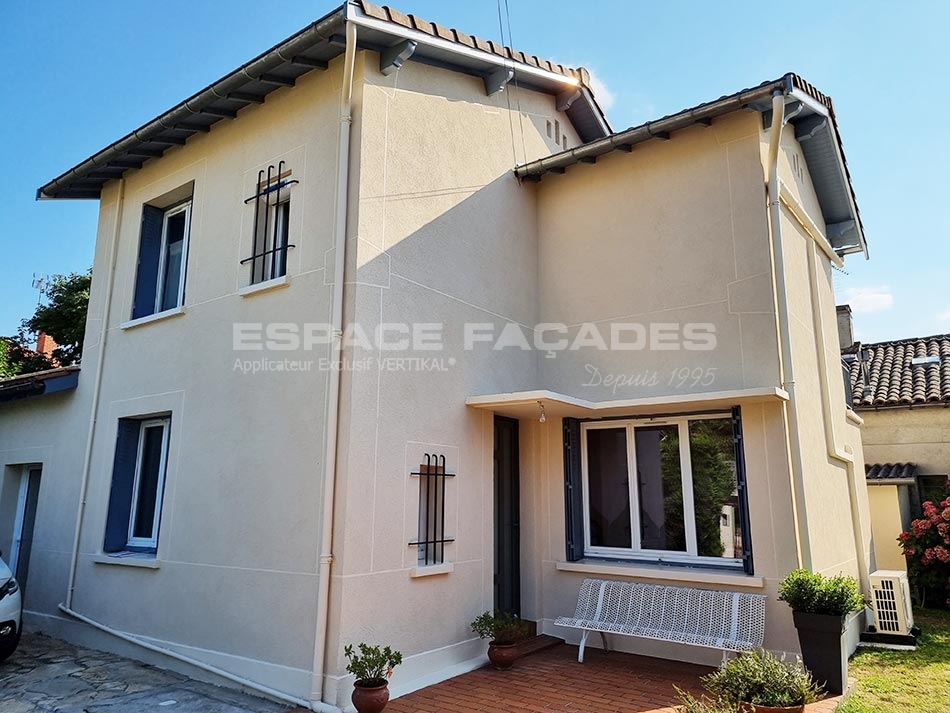 Maison avec façade en stuc, fenêtres et plantes